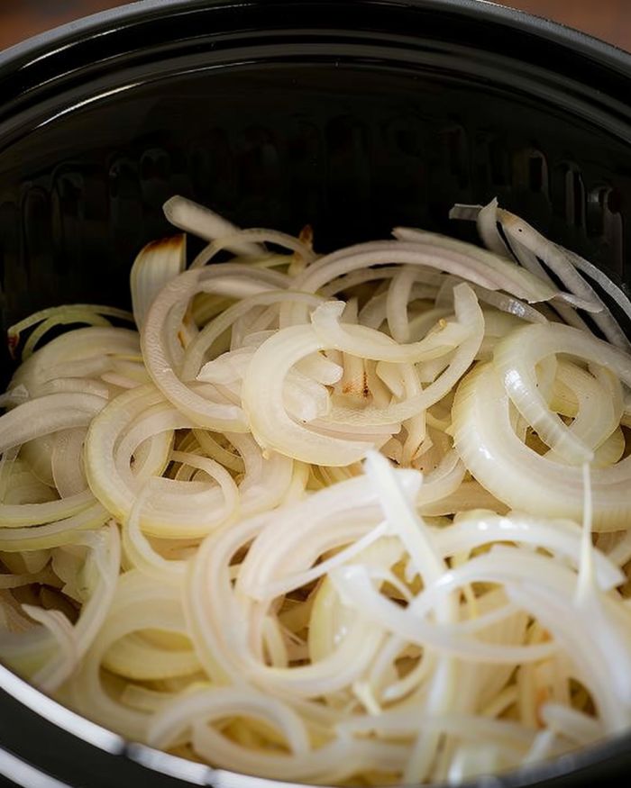 Toss the onions into the bottom of your slow cooker & pop pork chops on top. But hold on—the real magic is in the sauce that’s coming up